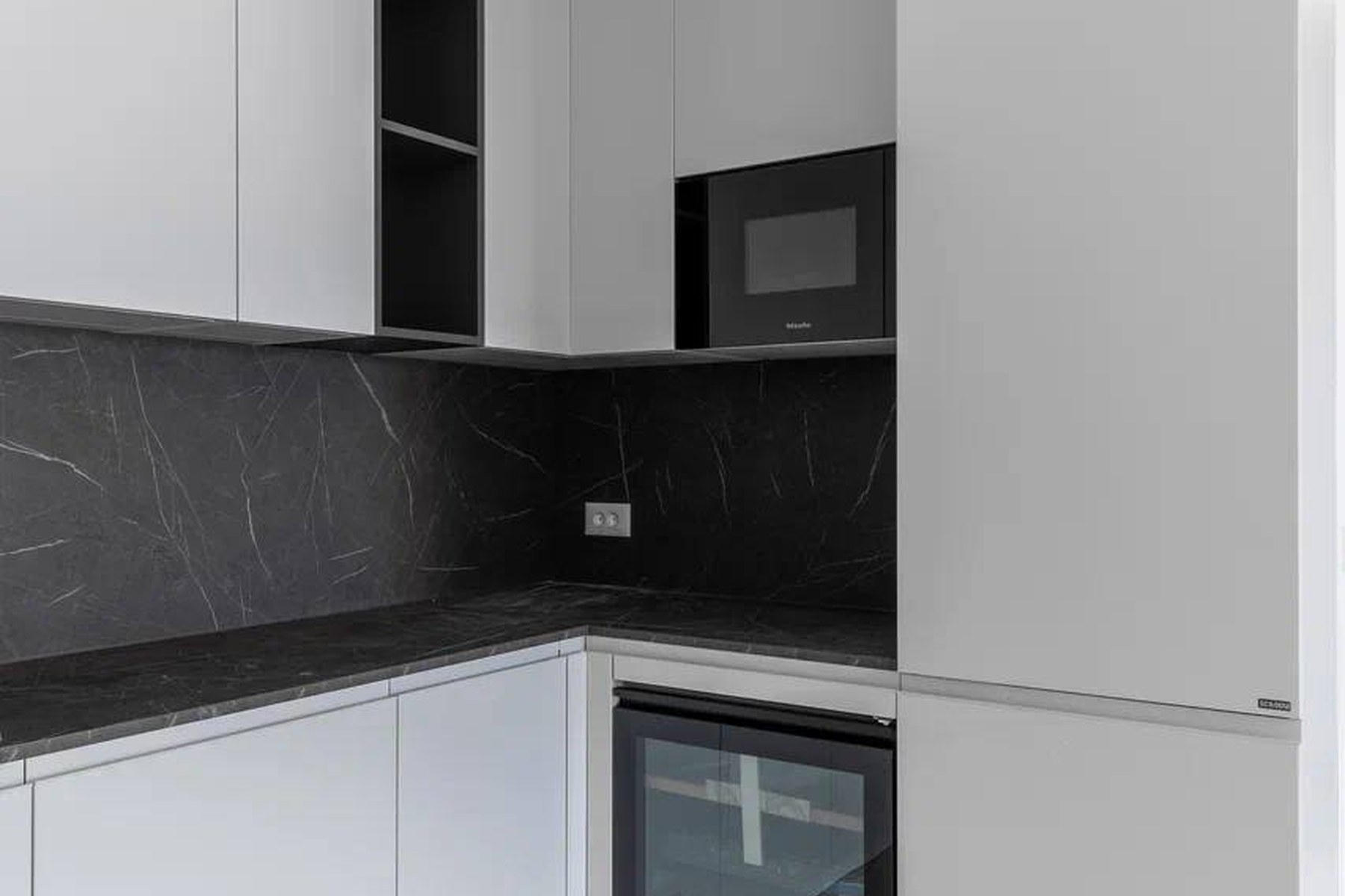 Marina Village 94 m² top-floor apartment, kitchen detail with integrated wine cooler and microwave