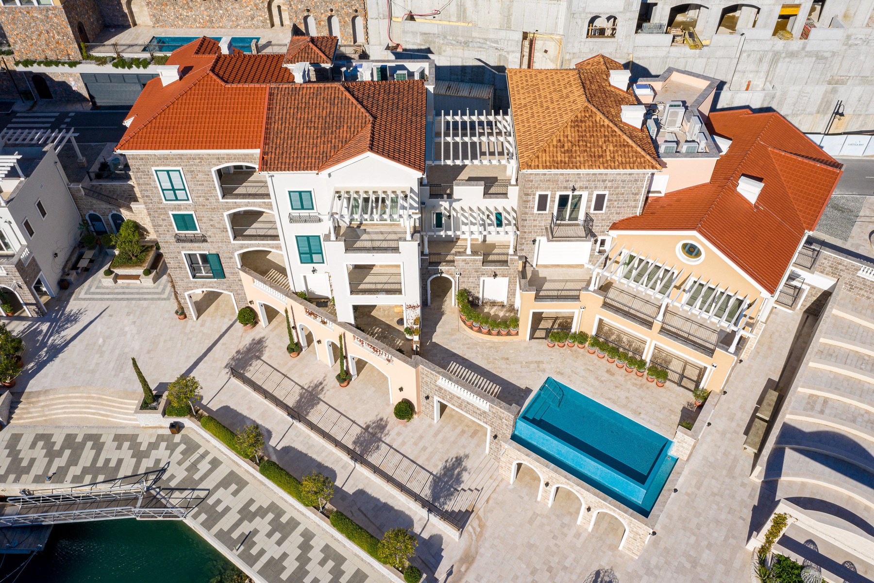 Curated top-floor one-bedroom apartment, aerial view of the Marina Village building complex with rooftop pools