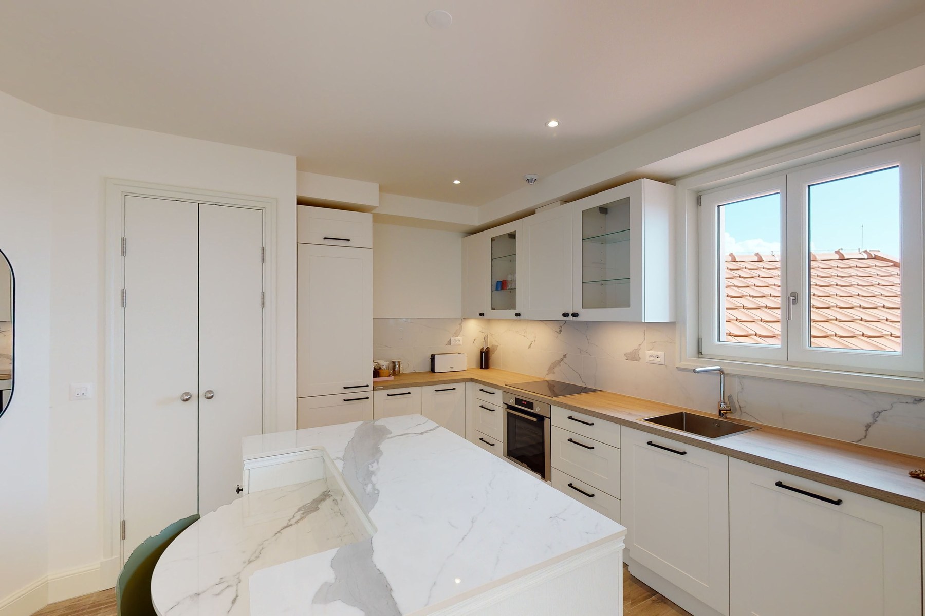 Curated top-floor one-bedroom apartment, kitchen with marble island and counters