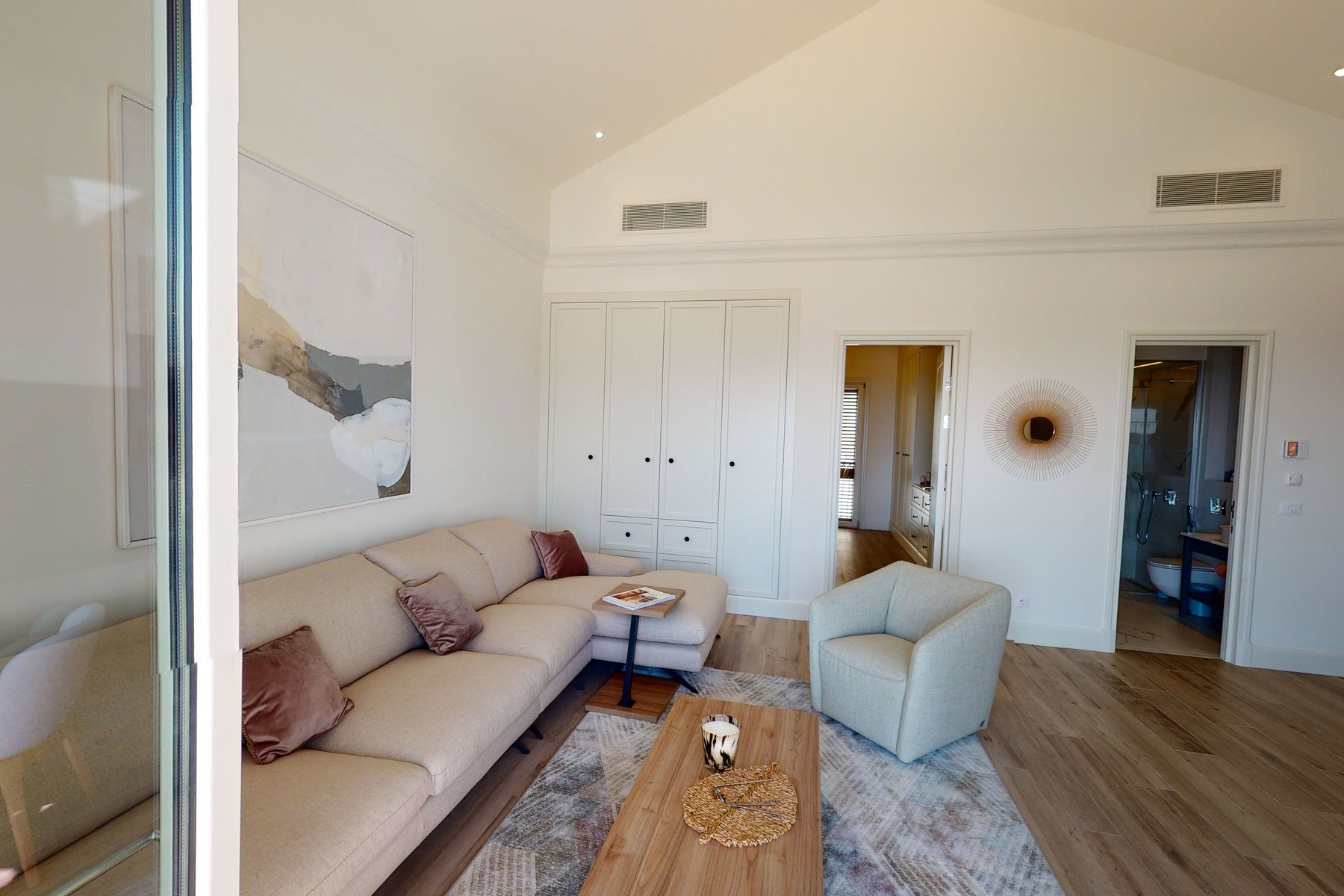 Curated top-floor one-bedroom apartment, living room with vaulted ceiling and bespoke art