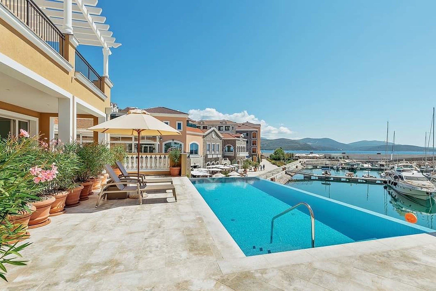 Curated top-floor one-bedroom apartment, pool deck with infinity pool and marina view