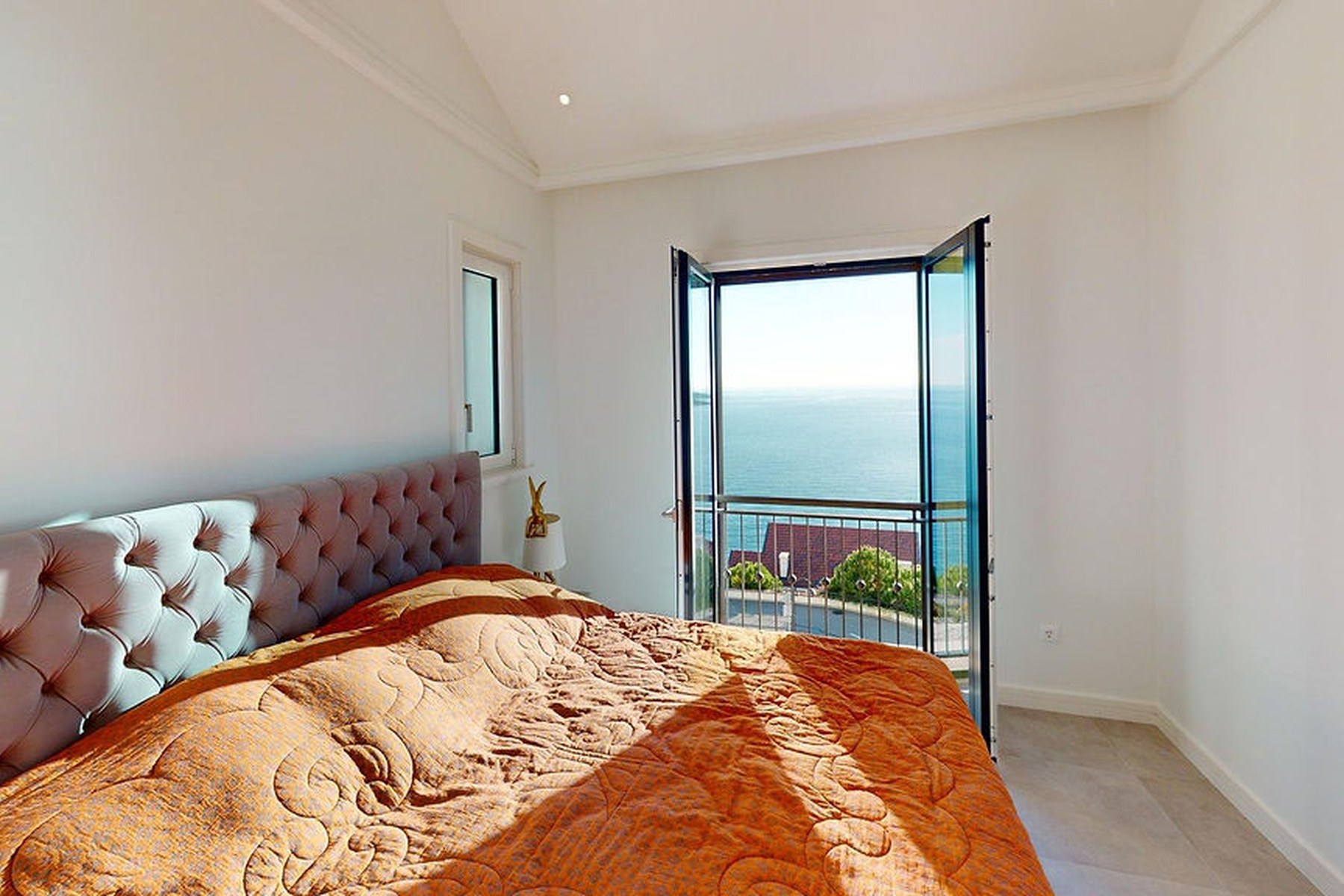 Panoramic top-floor one-bedroom apartment, bedroom with balcony door open to the sea